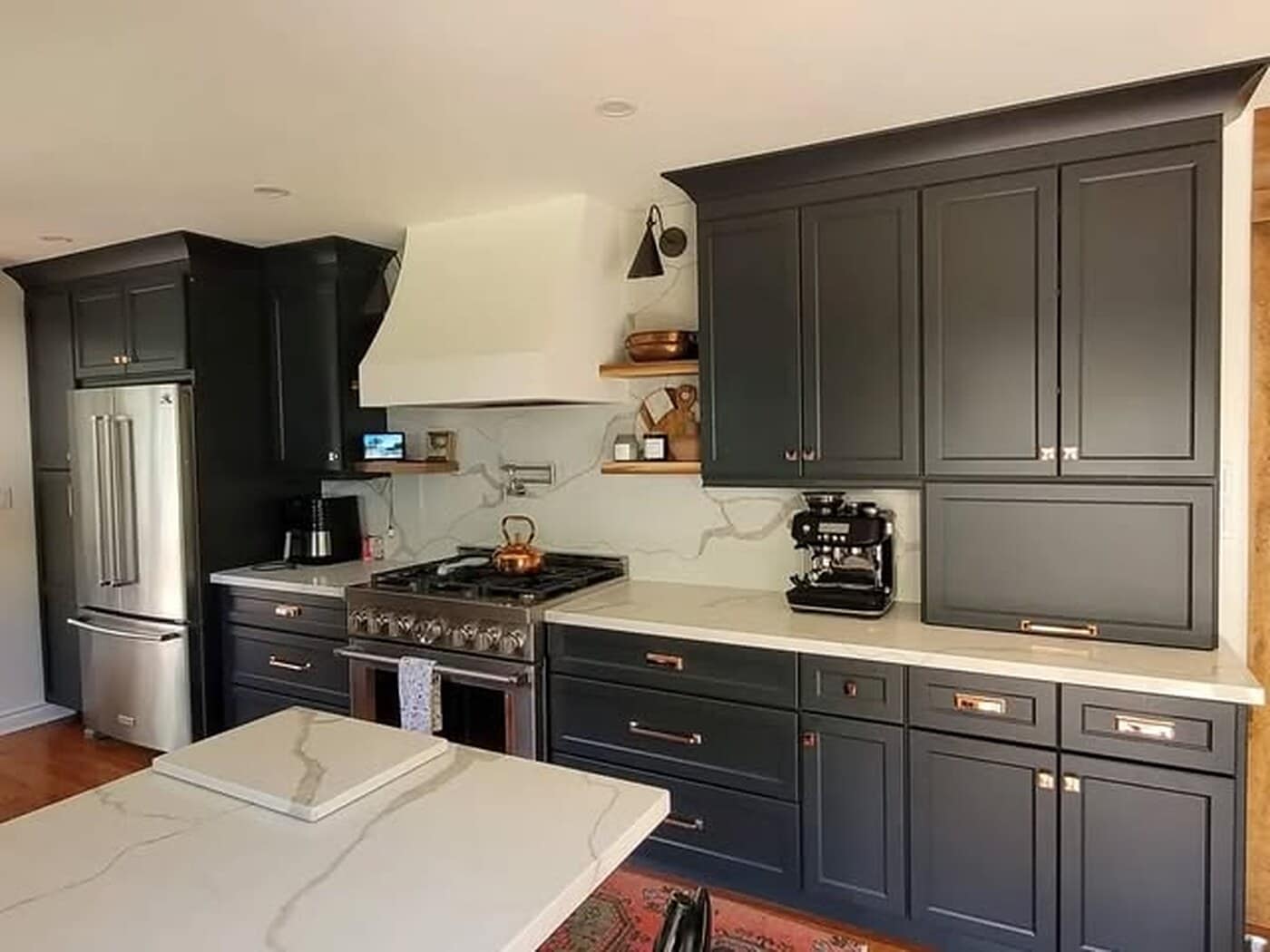 Cleaned kitchen with dark cabinetry, a stone island and a clear countertop